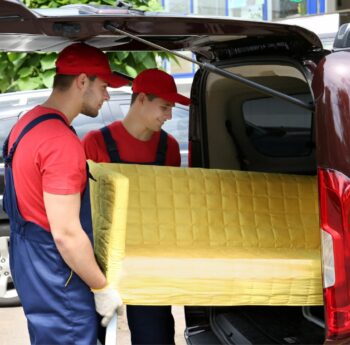 Günstig umziehen in Michelstadt: Umzugshelfer laden ein gelbes Sofa in einen Transporter