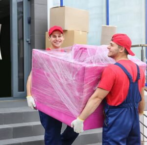 Zwei Umzugshelfer tragen ein in Folie gepacktes Möbelstück – Umzug in Michelstadt