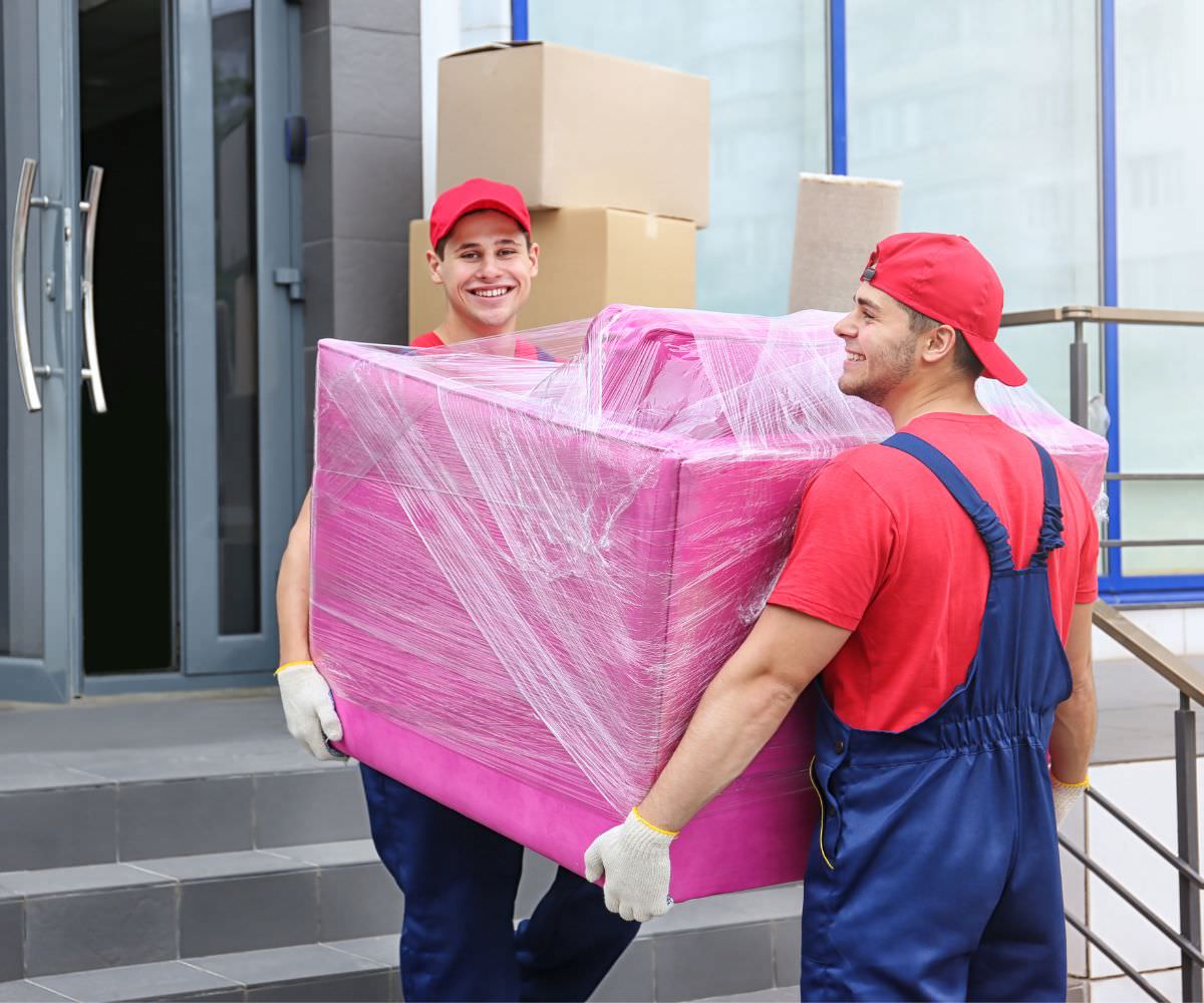 Michelstädter Umzugsunternehmen: Zwei Umzugshelfer tragen ein in Folie gepacktes Möbelstück
