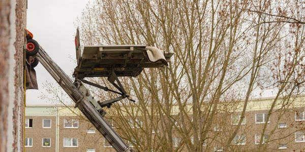 Möbellift zwischen kahlen Bäumen vor einem Gebäude – Möbellift in Michelstadt